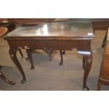 A Georgian mahogany games table of hinged rectangular form raised on cabriole legs with pad feet,
