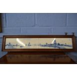 A 20th Century Delft tile panel depicting windmill and river scene, set in an oak frame, 102cm long