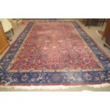 A large Turkish blue and red ground thick pile carpet decorated with stylised foliage and
