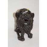 A terracotta black painted figure of a temple lion, 25cm high