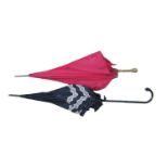 Two parasols, one in black satin with lace trim and swan neck handle, the other in red with gilt