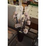 A tall vase and artificial flowers