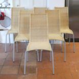 A set of six contemporary woven wicker kitchen chairs raised on anodised rodded and metal