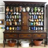 An antique and later adapted north country oak dresser having tiered open plate rack over a
