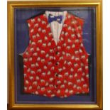 A framed silk waistcoat and bow-tie, decorated with repeating French bulldogs, overall framed size
