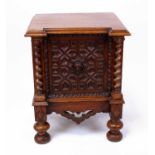 A late 19th century oak single door cupboard, having a centre geometric mask panel flanked by spiral