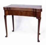 A mid-18th century mahogany triple-leaf games table, having a baize lined fold-over top with