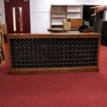 A Victorian style oak 140-bottle capacity wine rack, raised upon a plinth, w.206cm, d.28cm, h.89cm