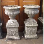 Pair of weathered cast concrete pedestal garden planters, each with a plinth base, 83cm high