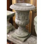 Group of three weathered cast concrete garden pedestal urns