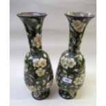Pair of Doulton Lambeth faience baluster form vases with painted floral design on a green ground,