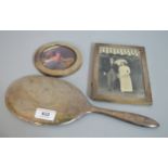 Sterling silver backed hand mirror, together with two silver mounted photograph frames