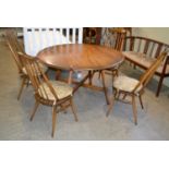 A mid-century Ercol drop leaf dining table, with X shaped stretcher, 72cm high x 114cm long;