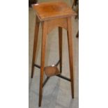 An Arts & Crafts style oak plant stand, with squared top and four tapered legs joined by an X shaped