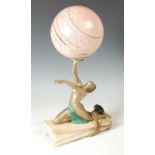 An Art Deco cold painted spelter table lamp, with globe shade, featuring a kneeling female figure,