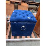 A modern blue velvet upholstered storage ottoman