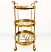 GILT METAL DRINKS TROLLEY WITH PALM TREE DESIGN SHELVES.