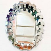 CONTEMPORARY OVAL WALL MIRROR WITH SEGMENTED MIRRORED FRAME.