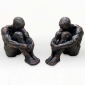PAIR OF SITTING MAN SCULPTURES IN BRONZED FINISH RESIN.