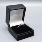 AN 18CT WHITE GOLD RUBY AND DIAMOND TRILOGY RING.