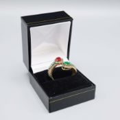 A SILVER-GILT RUBY, EMERALD AND DIAMOND DRESS RING.