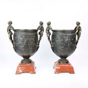 PAIR OF CLASSICAL DESIGN BRONZE URNS ON RED MARBLE BASES.