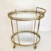 GILT METAL DRINKS TROLLEY WITH PIERCED GALLERIES AND MIRRORED GLASS.