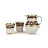 An early 19th century Derby porcelain jug and two matching beakers, each with hand painted floral