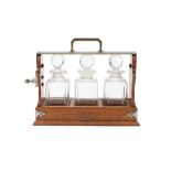 A Victorian oak tantalus with three glass decanters 34.5cm wide 14cm deep 29cm high