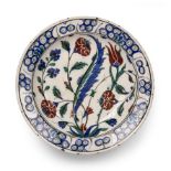 An Iznik shallow bowl with floral decoration 29.5cm diameter