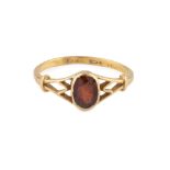 A garnet single stone ring, the oval-cut garnet collet set between pierced shoulders, to a 22ct gold