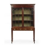 A George III mahogany bookcase cabinet on stand with two glazed doors above two drawers and square