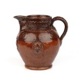 A 19th century redware salt glazed jug with face mask mount marked Cardinal Wiseman 29cm wide 27cm