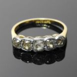 An 18 carat gold and platinum set five stone diamond ring, rubover set with a row of graduated