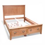 A modern pine double bedstead, with two short drawers, having a slatted wooden base 207w x 149d x