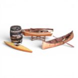 A mid 20th century scratch built wooden model of a kayak, 85cm long, together with a wooden rowing