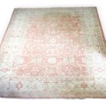 A Turkish carpet, with scrolled foliate designs on a pale red ground, 301 x 254cm