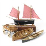 A collection of hand-built wooden model boats and carriages, to include a canoe and a rowing boat (