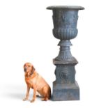 A large mid 20th century painted cast iron garden urn, of classical form, decorated in relief with