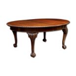 A mahogany dining table in the manner of Waring & Gillow, the piecrust edge above carved cabriole