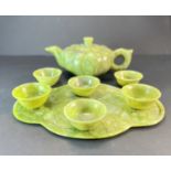 A Chinese carved spinach jade teapot with 6 matching cups.