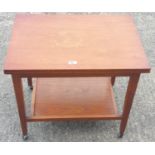 A 1960's "G Plan" style teak fold over swivel top, two tier games table.