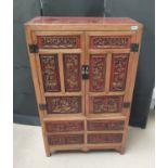 An oriental deeply carved tallboy/drinks cabinet featuring traditional scenes with hand painted