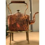 A 19th century copper kettle on brass trivet stand