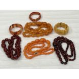 Four resinous amber coloured bead necklaces and three bangles