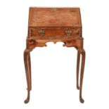 A George II yew wood bureau-on-stand, in the solid with sliding well to the serpentine interior, the