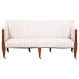 A George IV mahogany settee, upholstered in later pale grey striped fabric, the turned arm