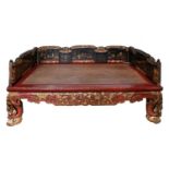 A Chinese carved and stained hardwood opium day bed, early 20th c, the three-quarter back of black