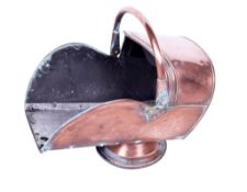 A copper coal scuttle. Having a swing handle and mounted on a circular base, H44cm.