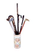 A ceramic stick stand and a collection of walking canes.